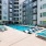 Large sparkling blue pool with a large pool deck and lounge chairs