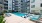 Large sparkling blue pool with a large pool deck and lounge chairs