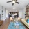 Spacious and well lit living room with wood flooring, large windows and open access to the kitchen